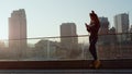 Stylish woman using phone outside. Beautiful girl looking to cellphone outdoor. Royalty Free Stock Photo