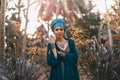 Stylish woman wearing turban with with gem stones accessories outdoors at sunset