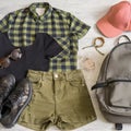 Stylish women`s or teenager`s clothing set with accessories: checkered shirt, black jersey top, green jeans shorts, pink cap, Royalty Free Stock Photo