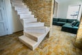 Stylish wooden contemporary staircase inside loft house interior. Modern hallway with decorative limestone brick walls and white Royalty Free Stock Photo