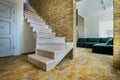 Stylish wooden contemporary staircase inside loft house interior. Modern hallway with decorative limestone brick walls and white Royalty Free Stock Photo