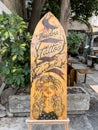 Budva, Montenegro - 08 august 2023: Stylish wooden signboard on a surfboard. Caption: Budva tattoo ink