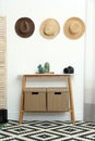 Stylish wooden table with boxes at white wall