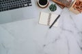 Stylish working table with laptop, notebook and stationery on marble background.