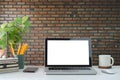 Stylish workplace with laptop computer, coffee cup, smart phone, books and potted plant on white table Royalty Free Stock Photo