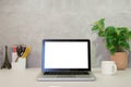 Stylish workplace with laptop computer, coffee cup, smart phone, books and potted plant on white table Royalty Free Stock Photo