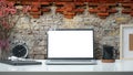 Stylish workplace with laptop computer, coffee cup and stationery on white table against brick wall. Blank screen for your Royalty Free Stock Photo