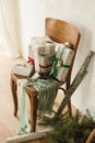 Stylish wrapped christmas gifts with ribbons on old wooden chair, festive paper and wicker basket with spruce branches in rural Royalty Free Stock Photo