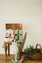 Stylish wrapped christmas gifts with ribbons on old wooden chair, festive paper and wicker basket with spruce branches in rural Royalty Free Stock Photo