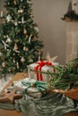 Stylish wrapped christmas gifts, rustic basket with fir branches and modern decorations on table close up. Merry Christmas and Royalty Free Stock Photo