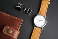 Stylish wrist watch, cuff links and wallet on black. Fashion accessory