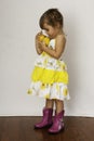Stylish 3 year old girl in yellow dress holding lemons