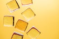 Stylish yellow background with transparent ice-like cubes for drinks. Flat lay macro photo Royalty Free Stock Photo