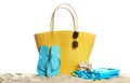 Stylish yellow bag and beach accessories on sand Royalty Free Stock Photo