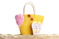 Stylish yellow bag and beach accessories on sand Royalty Free Stock Photo