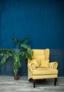 Stylish Yellow chair against a blue wall Royalty Free Stock Photo