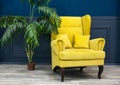 Stylish Yellow chair against a blue wall Royalty Free Stock Photo