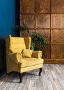 Stylish Yellow chair against a blue wall Royalty Free Stock Photo