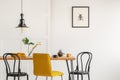 Yellow chair at wooden dining table in trendy interior