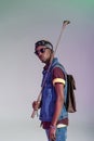 stylish young african american man holding golden golf club and looking at camera