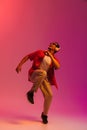 African man enjoying music and dancing over gradient neon background