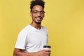 Stylish young afro american man holding cup of take away coffee isolated over yellow background Royalty Free Stock Photo