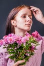 Stylish beautiful passionate girl with pink chrysanthemum on dark background