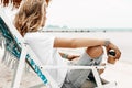 Stylish young beautiful woman in casual wear relaxing in chair o