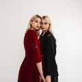 Stylish young beautiful women with blond hair in fashion dresses indoors. Two fashionable girlfriends in vintage clothes in retro Royalty Free Stock Photo