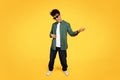 Stylish young black guy wearing sunglasses playing imaginary guitar Royalty Free Stock Photo