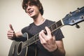 Stylish young blonde hipster man playing guitar Royalty Free Stock Photo