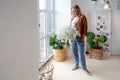 Stylish young blonde woman with a bouquet of gypsophila. Portrait in the interior.