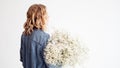 Stylish young blonde woman with a bouquet of gypsophila. Portrait on a white background.