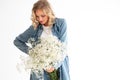 Stylish young blonde woman with a bouquet of gypsophila. Portrait on a white background.