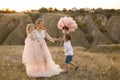 Stylish young boy gives a big flower to his mom in a field at sunset Royalty Free Stock Photo