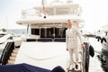 Stylish businessman is standing on his luxury yacht is wearing white fashion costume. Montenegro bay Royalty Free Stock Photo