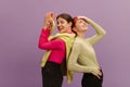 Stylish young caucasian girls wearing casual clothes in good mood pose on purple background. Royalty Free Stock Photo