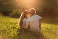 Stylish young couple sitting on a hill and admiring the sunset. A film photo with a light and a sunlight, a Royalty Free Stock Photo