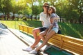 Stylish young couple teenagers sitting on the bench city, summer day Royalty Free Stock Photo