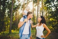 Stylish young Family of mom, dad and daughter one year old blonde sitting near father on shoulders, outdoors outside the city in a Royalty Free Stock Photo