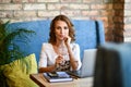 Stylish young girl businesswoman working in a cafe at the computer. Coffee break