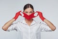 Stylish young girl puts on red face mask and gloves. Concept for preventing coronavirus covid 19 Royalty Free Stock Photo