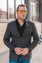 Stylish young guy portrait businessman of European appearance in a gray jacket and black shirt in sunglasses on the street outdoor Royalty Free Stock Photo