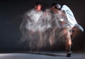 Stylish young guy rapper stands in neon light. Long exposure shot. Battle competition announcement