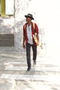 Stylish young guy walking outdoors with skateboard Royalty Free Stock Photo