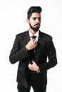 Stylish young indian businessman in suit and tie. Business style. Handsome man is fixing his tie isolated on white Royalty Free Stock Photo