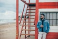 Stylish young man with a beard standing near ocean with a cup of tea Royalty Free Stock Photo