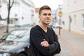 Stylish young man in a black T-shirt near the car. Royalty Free Stock Photo