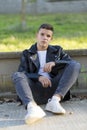 Stylish young man in leather jacket looking at camera, sitting i Royalty Free Stock Photo