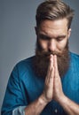 Young man sitting pensively against a gray background Royalty Free Stock Photo